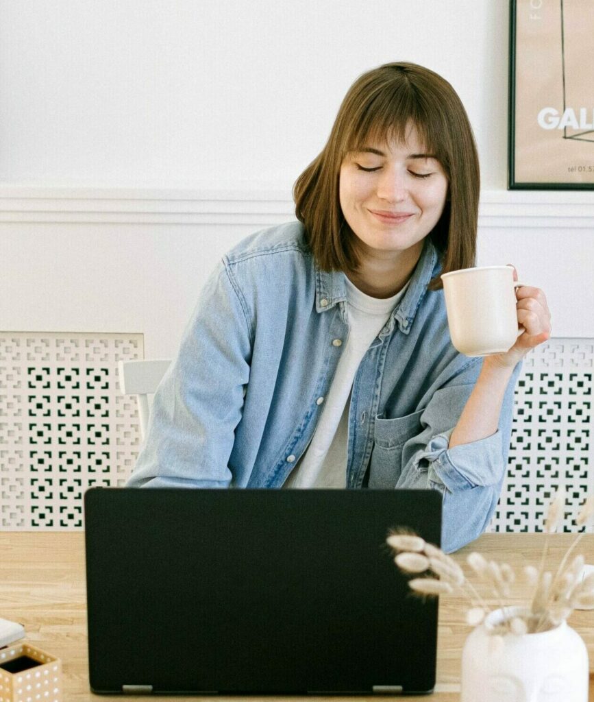 Woman drinking coffee while writing a blog